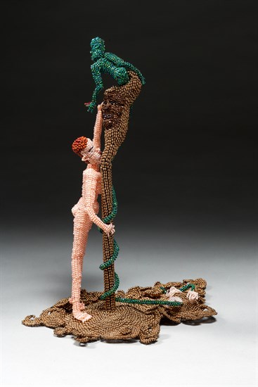 Joyce Scott, Study II (Adam and Eve), 2009. Hand beaded construction of Eve reaching for an apple with the Tree Of Knowledge, set in a swirling pool of gold with skeletal figure emerging and serpent in the tree.