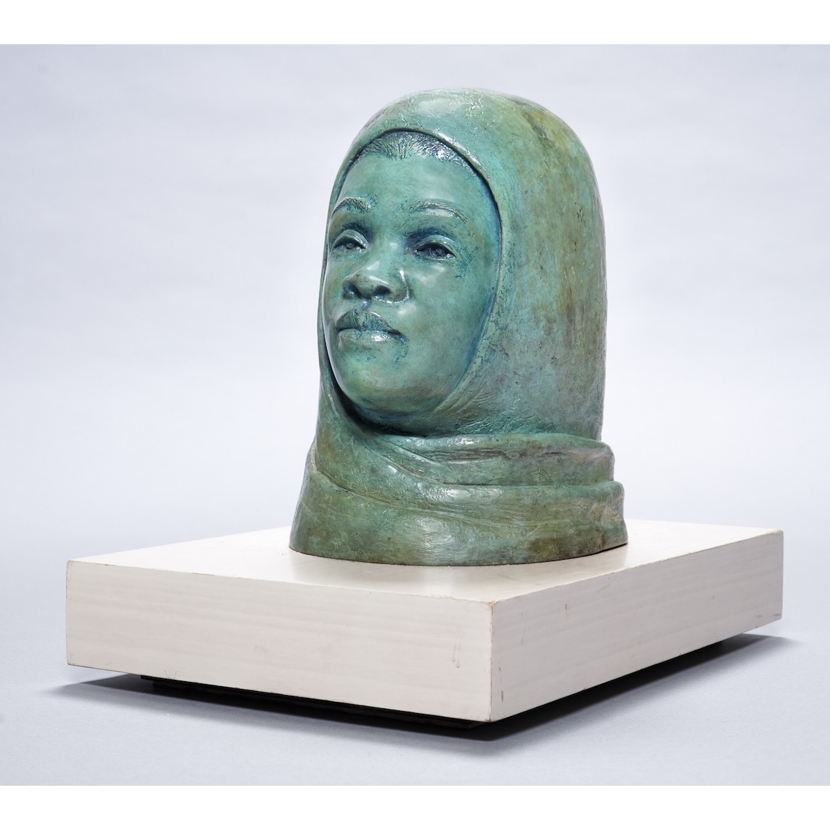 Image of a bronze sculpture of a young woman in a head wrap by the artist Otto Neals